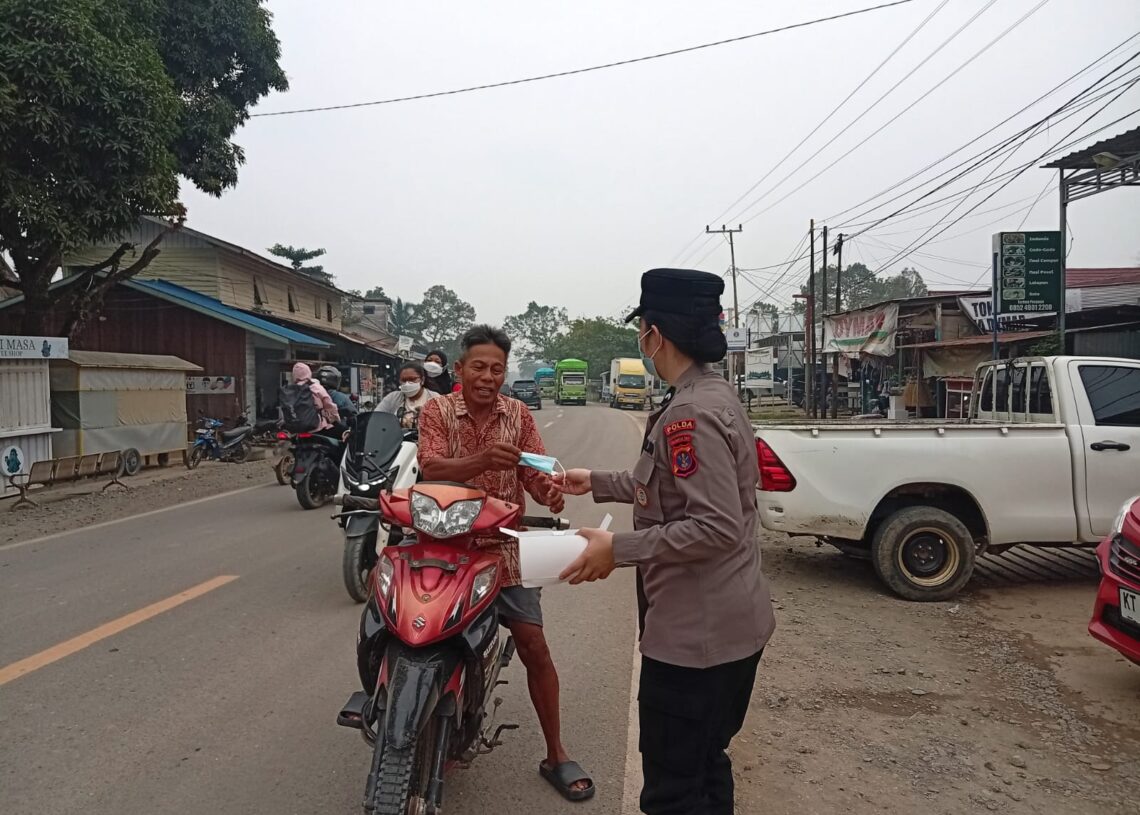 Antisipasi Dampak Asap Karhutla, Polsek Kongbeng Bagikan Masker ke Warga Marga Mulya